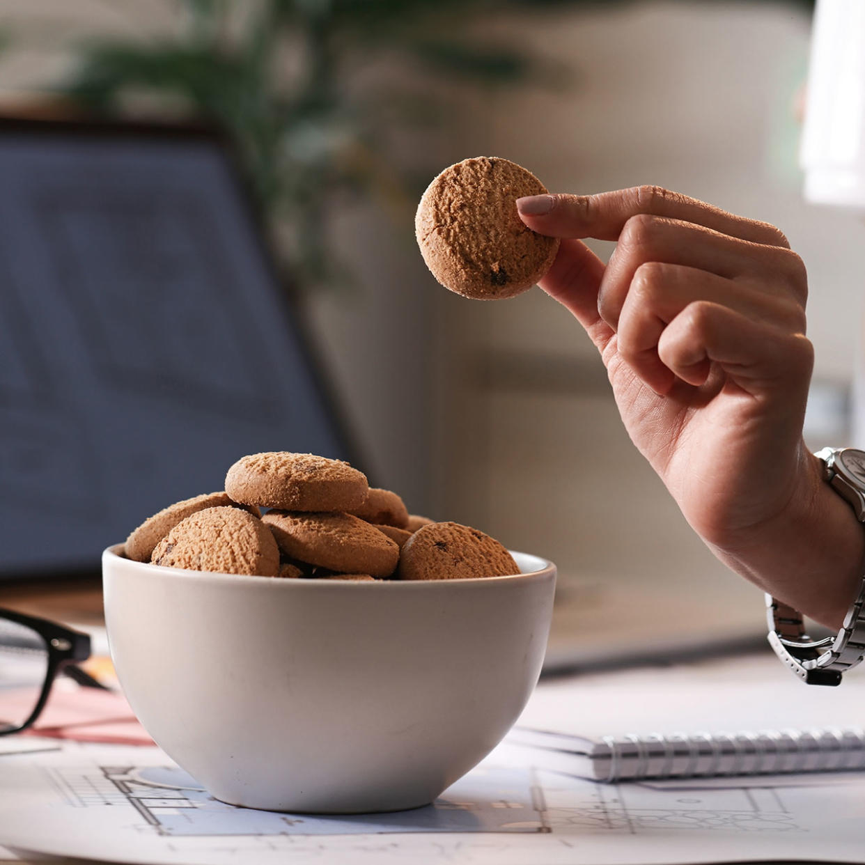 woman snacking on cookies during work