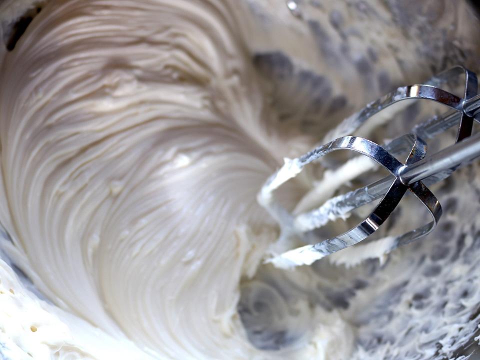 hand mixer whipping frosting in bowl