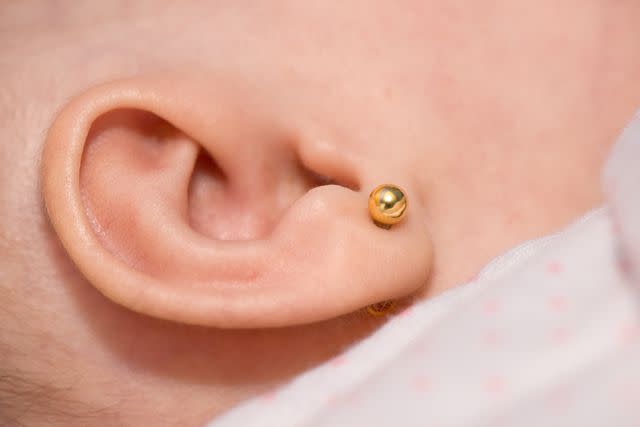 <p>Getty</p> A stock photo of a baby with an ear piercing