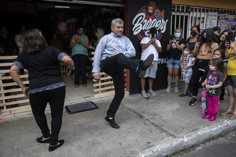 Fabio Rodolfo Vásquez y su esposa bailando en un evento publicitario frente a una cafetería de Ciudad de Guatemala el 19 de septiembre del 2020. (AP Photo/Moisés Castillo)