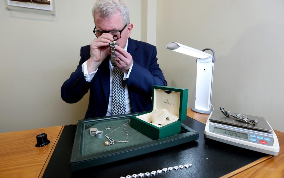 Jim Tannahill examines a Rolex to check its authenticity. 'Not a day goes by when we don't get a fake watch in here'