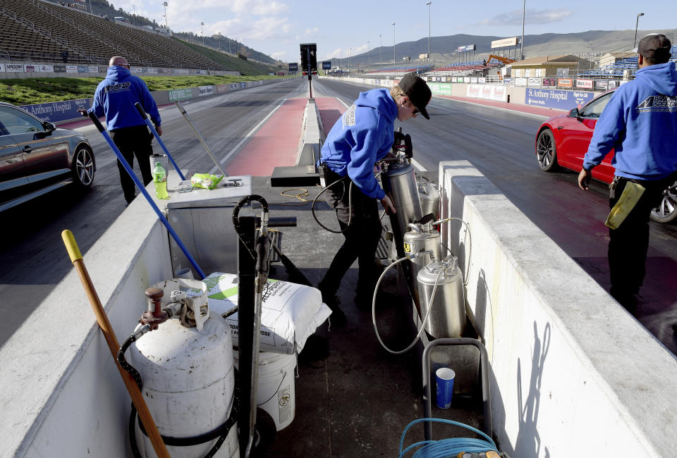 A crew readies the track at Bandimere Speedway west of Denver on May 5, 2021. The Colorado State Patrol runs a program called "Take it to the Track" in hopes of luring racers away from public areas to a safer and more controlled environment, even allowing participants to race a trooper driving a patrol car. The program's goals have gained new importance and urgency this year as illegal street racing has increased amid the coronavirus pandemic. (AP Photo/Thomas Peipert)