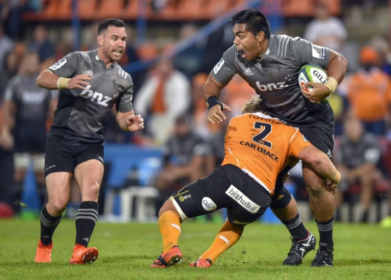 The Central Cheetahs' Torsten van Jaarsveld (C) tackles the Canterbury Crusaders' Seta Tamanivalu during their Super Rugby match, at the Bloemfontein stadium in South Africa, on April 29, 2017