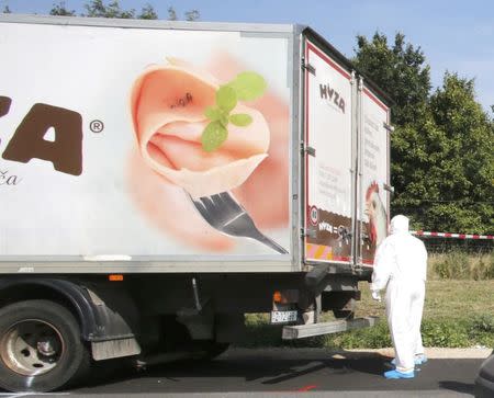 A forensic police officer stands next to a parked truck in which up to 50 migrants were found dead, on a motorway near Parndorf, Austria August 27, 2015. REUTERS/Heinz-Peter Bader