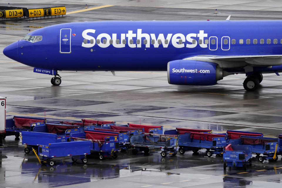 A Southwest Airlines jet passes unused luggage carts as it arrives, Dec. 28, 2022, at Sky Harbor International Airport in Phoenix. Congress is hearing today about the December meltdown at Southwest Airlines. A Southwest executive said in prepared testimony Thursday, Feb. 9, 2023 that the airline is taking steps to avoid a repeat of the breakdown that led to nearly 17,000 canceled flights over the December holidays. (AP Photo/Matt York, file)