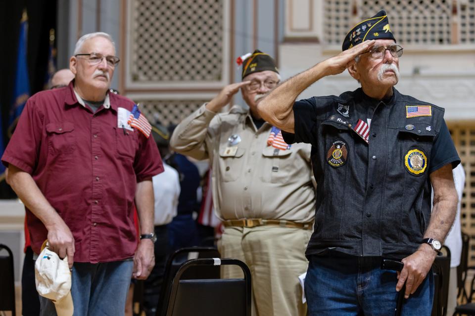 People salute the flag during the playing of taps at the Memorial Day observance Monday at Stockton Memorial Civic Auditorium in Stockton.