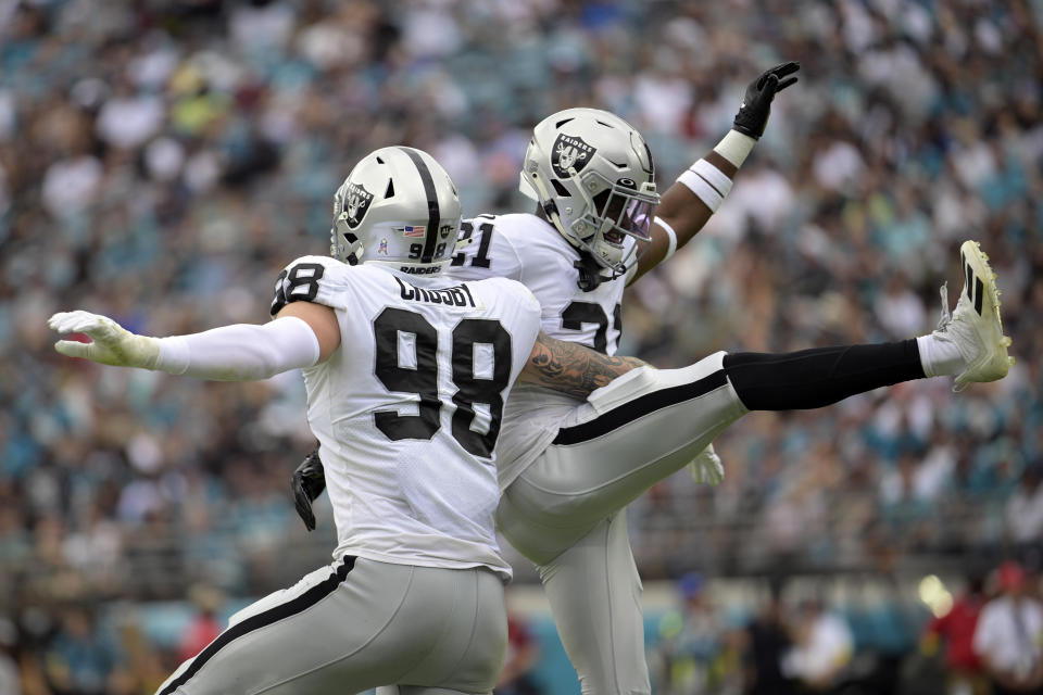 Las Vegas Raiders defensive end Maxx Crosby (98) and cornerback Amik Robertson celebrate after a play against the Jacksonville Jaguars in the first half of an NFL football game Sunday, Nov. 6, 2022, in Jacksonville, Fla. (AP Photo/Phelan M. Ebenhack)