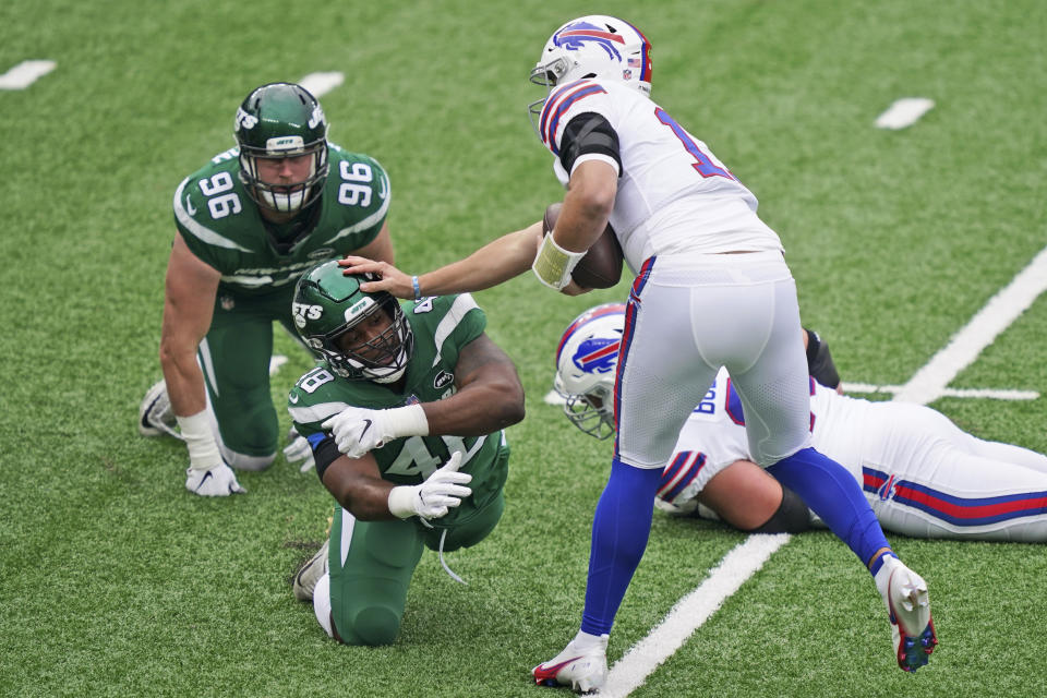 Buffalo Bills quarterback Josh Allen (17), right, holds off New York Jets' Jordan Jenkins during the first half of an NFL football game, Sunday, Oct. 25, 2020, in East Rutherford, N.J. (AP Photo/John Minchillo)