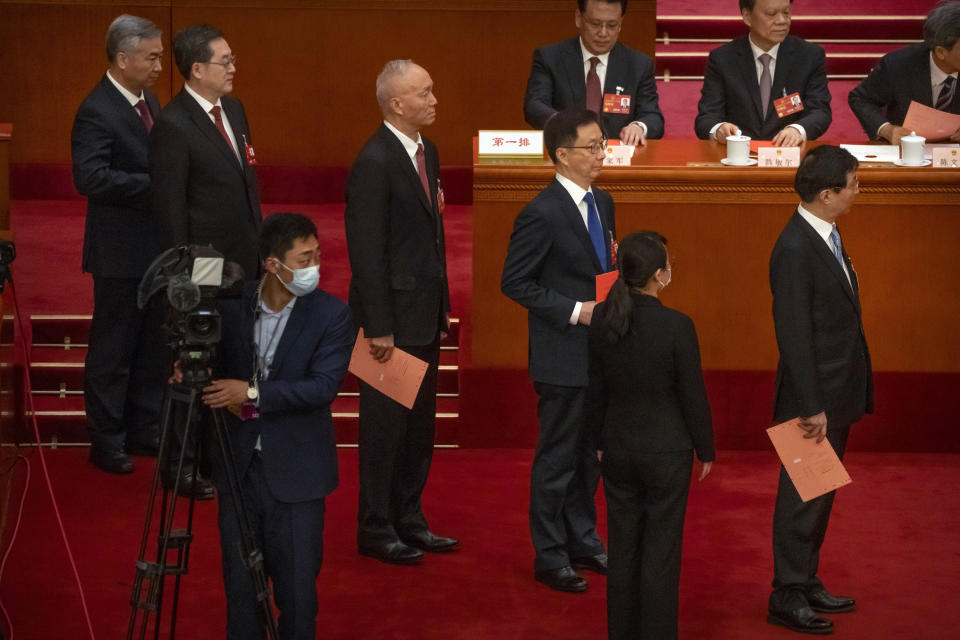 From left, Li Xi, Ding Xuexiang, Cai Qi, Han Zheng, and Wang Huning wait to cast their ballots during a session of China's National People's Congress (NPC) at the Great Hall of the People in Beijing, Friday, March 10, 2023. Six men sit alongside Chinese leader Xi Jinping on the ruling Communist Party's all-powerful Politburo Standing Committee, handling major portfolios from propaganda to corruption fighting. (AP Photo/Mark Schiefelbein)