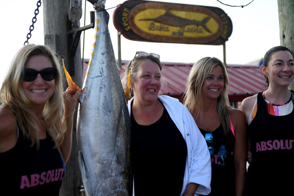 Angler Cheryl Martin takes a photo with her 63.5 pound tuna and the Rhondas Osprey crew at the Captain Steve's Poor Girls Open Thursday, Aug. 18, 2022, at Bahia Marina at Fish Tales in Ocean City, Maryland.