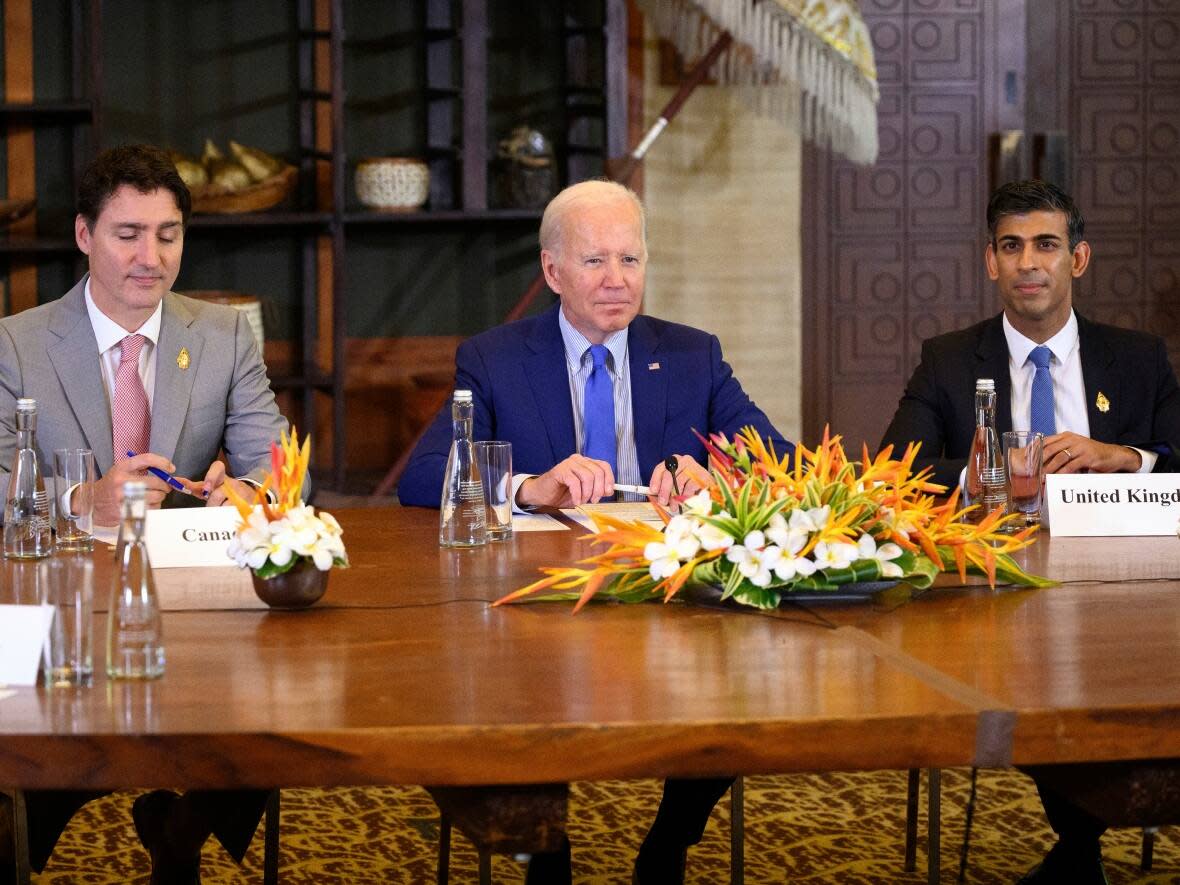 U.S. President Joe Biden, center, Prime Minister Justin Trudeau, left, and British Prime Minister Rishi Sunak attend a G20 meeting in Indonesia. The three countries have jointly endorsed a U.S. framework to fight foreign information manipulation. (Leon Neal/Associated Press - image credit)