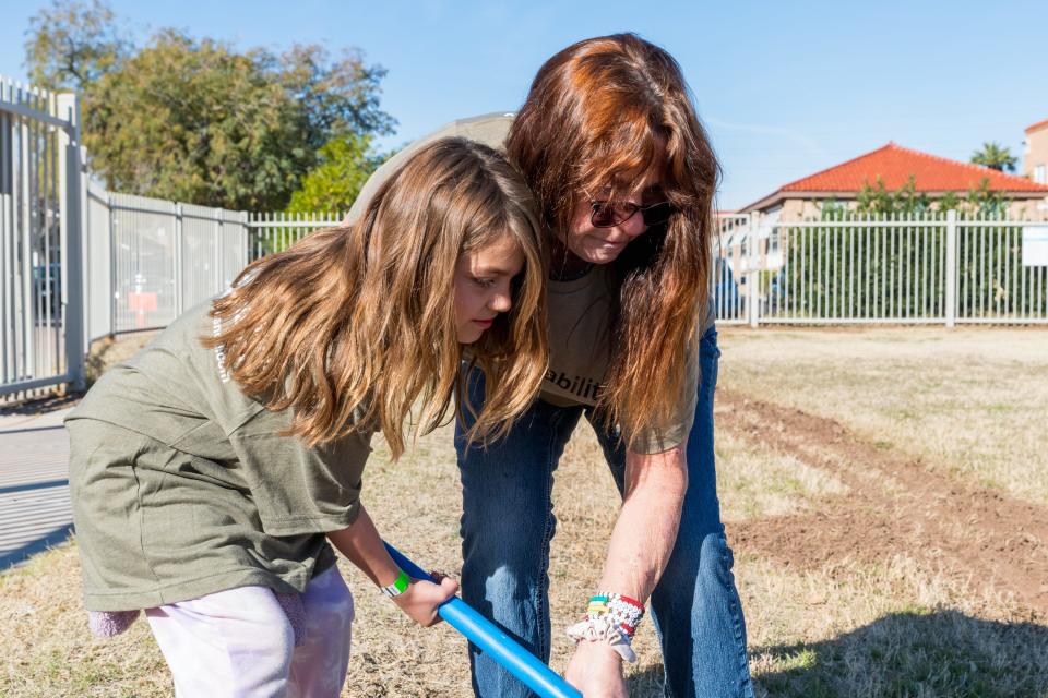 Debbie Easley, right, helps her granddaughter, Xenny Herrera, 7, dig a hole at a tree planting event hosted by the Arizona Sustainability Alliance at Emerson Elementary School in Phoenix, Ariz., on Feb. 27, 2022.