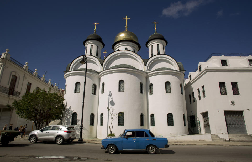 A Russian Moscovich car drives past the Russian Orthodox Cathedral in Havana, Cuba, Monday, Oct. 14, 2019. Neither country provides many details about their improving relations, but Russian products being exported to Cuba include new-model Lada automobiles and Kamaz trucks. (AP Photo/Ismael Francisco)