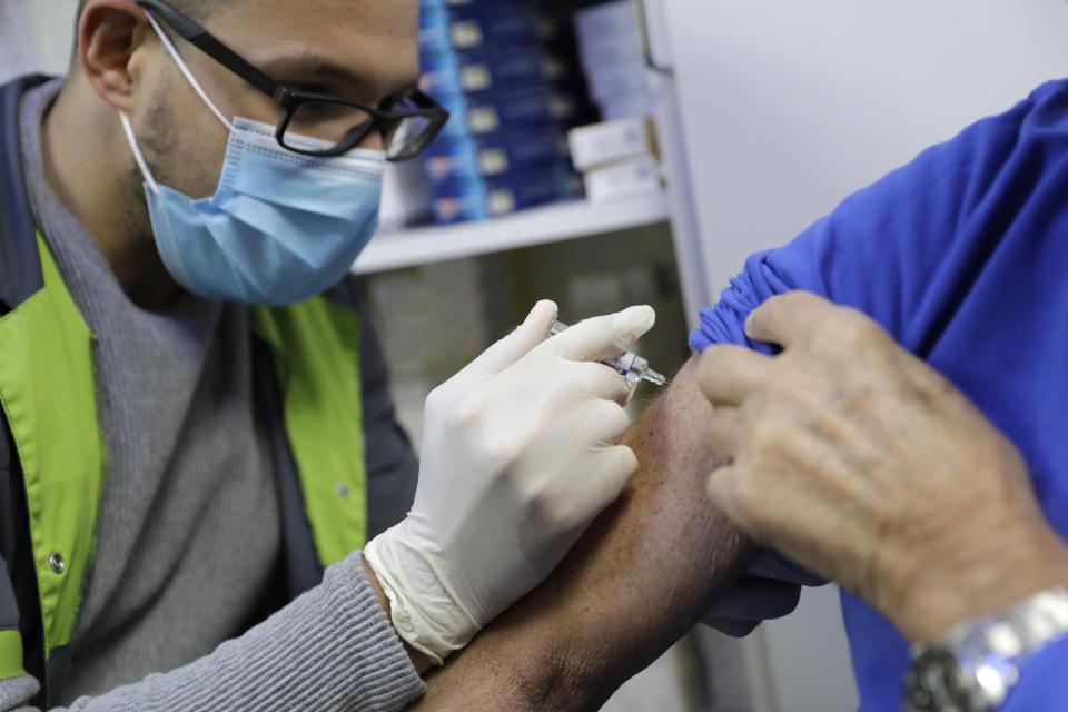 FILE - In this Wednesday, Oct. 14, 2020, file photo, a pharmacist administers a flu shot in a drugstore in Paris. On Friday, Oct. 30, 2020, The Associated Press reported on stories circulating online incorrectly asserting that new data shows flu cases are down 98% around the globe. Social media posts making this claim are providing incomplete information, relying solely on data from countries in the Southern Hemisphere like New Zealand and Australia. The Northern Hemisphere has yet to experience its full flu season. (AP Photo/Lewis Joly)