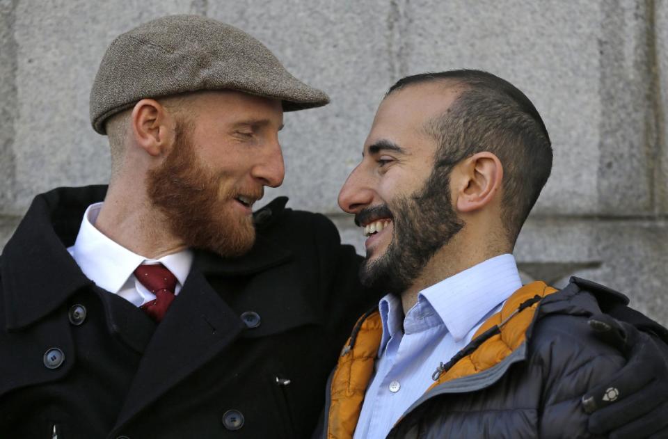 FILE - In this Dec. 4, 2013, file photo, Derek Kitchen, left, and his partner Moudi Sbeity hug each other outside Frank E. Moss United States Courthouse, in Salt Lake City. The young couple that has become the face of gay marriage in Utah is an unlikely pair for the role. Kitchen and Sbeity were both raised in conservative religious families that shun gays, Kitchen in a Mormon home in Utah and Sbeity in a Muslim family in Lebanon. They each came out when they were 16 years old, worlds apart, and met six years later in college in Utah. They chose to become one of three couples as plaintiffs in the lawsuit challenging Utah’s same-sex marriage to publicly push back against religions that oppress gays and lesbians. (AP Photo/Rick Bowmer, File)