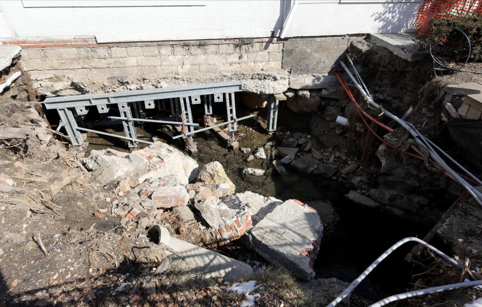 A giant hole where a drainage pipe was located, is pictured near The Bagel Emporium on Irving Avenue in Port Chester, Feb. 16, 2022. The underground drainage system burst during Hurricane Ida. 