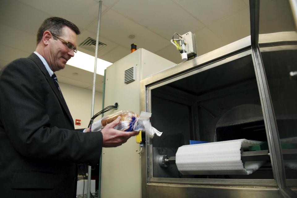 In this Dec. 6, 2012, photo, Don Stull, chief executive officer of Microzap, Inc., places a loaf of bread inside a patented microwave that kills mold spores in Lubbock, Texas. The company claims the technology allows bread to stay mold-free for 60 days. (AP Photo/John Mone)