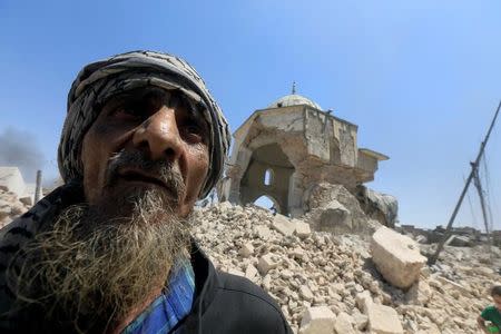 A displaced Iraqi man stands near the ruined Grand al-Nuri Mosque after fleeing from the Old City in Mosul, Iraq, June 30, 2017. REUTERS/Alaa Al-Marjani