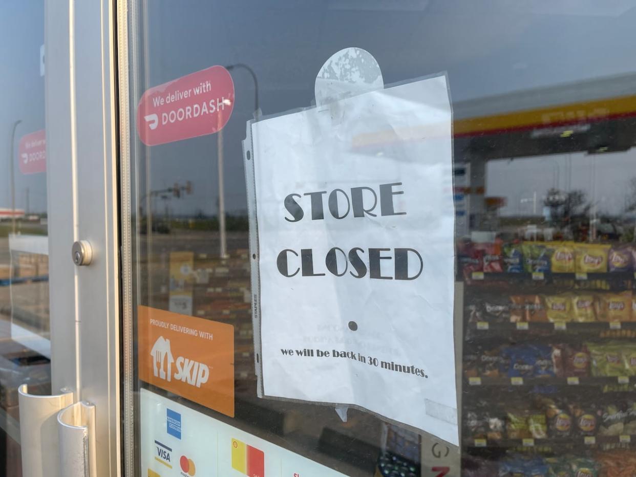 A store closure sign is displayed on the door of a Shell gas station in Fort McMurray. (Travis McEwan/CBC - image credit)