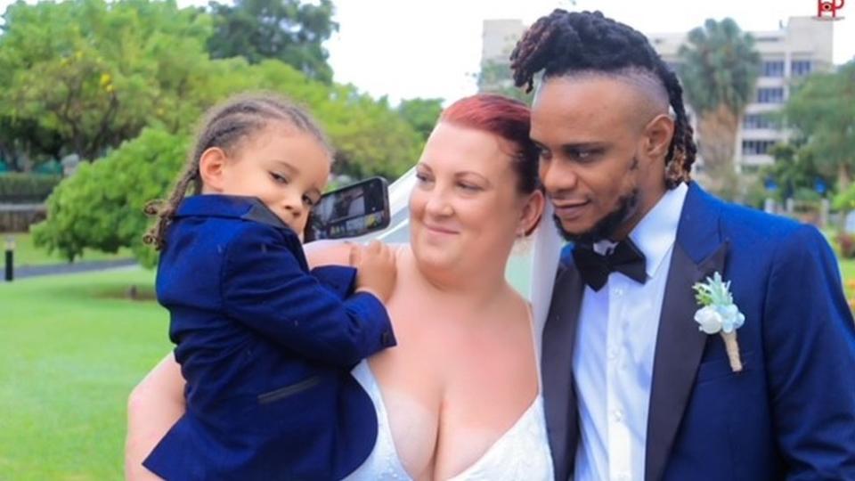 Lindsay Thompson in her wedding dress with her husband, Orlando, and their son, Arland