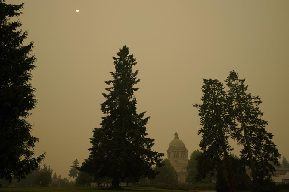 FILE - In this Sept. 12, 2020, file photo, smoke from wildfires in Oregon and California create hazy skies as the sun is seen above the Washington state Capitol in Olympia, Wash. Wildfires churning out dense plumes of smoke as they scorch huge swaths of the U.S. West Coast have exposed millions of people to hazardous pollution levels, causing emergency room visits to spike and potentially thousands of deaths among the elderly and infirm, according to an Associated Press analysis of pollution data and interviews with physicians, health authorities and researchers. (AP Photo/Ted S. Warren, File)