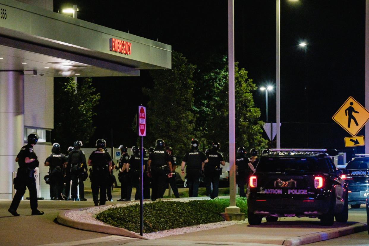 Akron police in riot gear stand near the emergency entrance at Cleveland Clinic Akron General during a lockdown late Wednesday night.