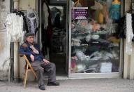 A Lebanese-Armenian man sits next to his shop in the Burj Hammoud area of Beirut on April 16, 2015