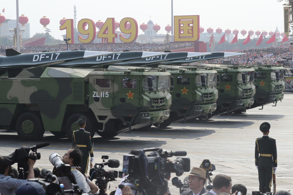 Military vehicles, carrying DF-17, roll down as members of a Chinese military honor guard march during the parade to commemorate the 70th anniversary of the founding of Communist China in Beijing, Tuesday, Oct. 1, 2019. China's military has shown off a new hypersonic ballistic nuclear missile believed capable of breaching all existing anti-missile shields deployed by the U.S. and its allies. The vehicle-mounted DF-17 was among weapons displayed Tuesday in a massive military parade marking the 70th anniversary of the founding of the Chinese state.(AP Photo/Ng Han Guan)