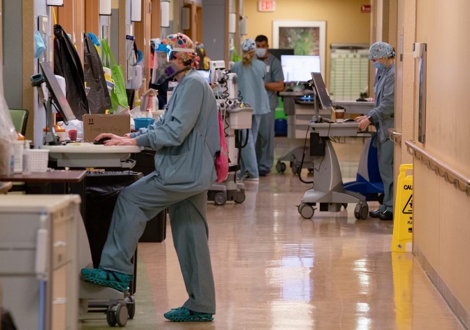 Nurses and doctors fill the hallways in the 10th floor COVID-19 unit at St. Joseph Mercy Hospital in Ypsilanti on April 20, 2021.