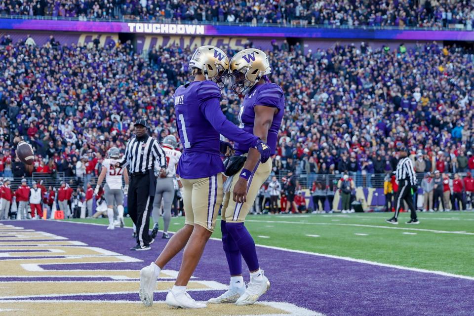 Nov 25, 2023; Seattle, Washington; Washington Huskies wide receiver Rome Odunze (1) celebrates with quarterback Michael Penix Jr. (9) after catching a touchdown against the Washington State Cougars during the second quarter at Alaska Airlines Field at Husky Stadium.