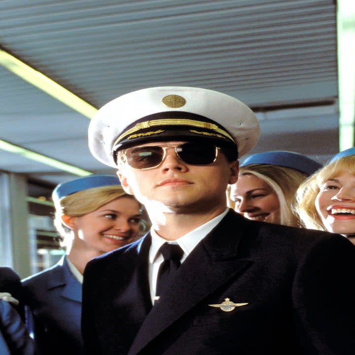 Leonardo DiCaprio as a pilot surrounded by flight attendents