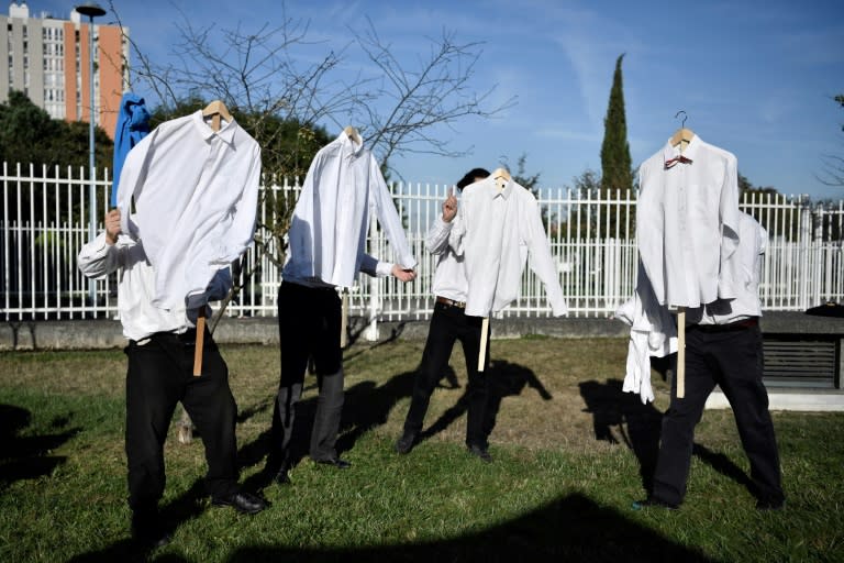 Theater performers hold shirts near Bobigny courthouse on September 27, 2016, where a trial is being held over rowdy scenes a year ago in which an Air France executive had his shirt ripped