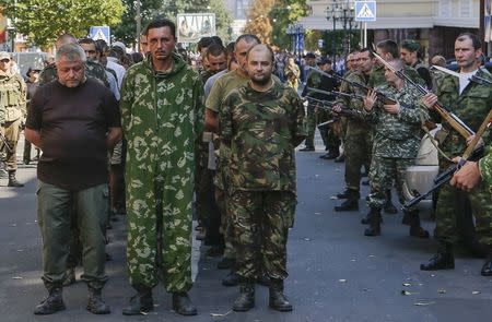 Armed pro-Russian separatists (R) escort a column of Ukrainian prisoners of war as they walk across central Donetsk August 24, 2014. REUTERS/Maxim Shemetov