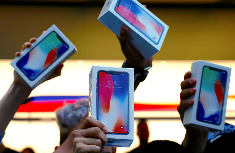 <p>The first customers to buy the iPhone X hold it aloft during the global launch of the new Apple product in central Sydney, Australia, November 3, 2017. REUTERS/David Gray </p>