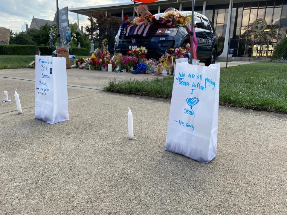 Luminaria bags featuring messages to Officer Seara Burton line the North Fifth Street sidewalk near Burton's K-9 vehicle at the Richmond Municipal Building.