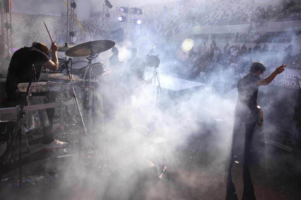 Israeli musician Ivri Lider perform in front of audience during a performance where all guests were required to show "green passport" proof of receiving a COVID-19 vaccination or full recovery from the virus at a soccer stadium in Tel Aviv, Friday, March. 5, 2021. (AP Photo/Oded Balilty)