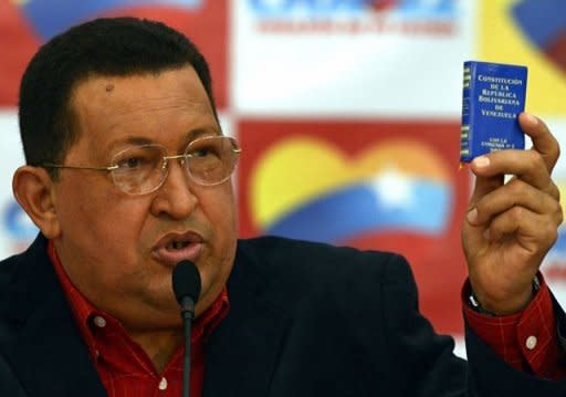 Venezuelan President Hugo Chavez holds up a copy of the Constitution during a press conference in Caracas. Chavez has insisted he is "totally" cancer-free a little more than a year since he was diagnosed and said he was ready to take on a re-election battle