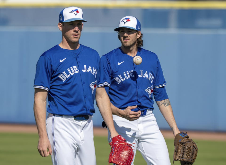 Toronto Blue Jays pitchers Chris Bassitt, left, and Kevin Gausman walk off the field after warming up at baseball spring training in Dunedin, Fla., Friday, Feb. 23, 2024.(Frank Gunn/The Canadian Press via AP)