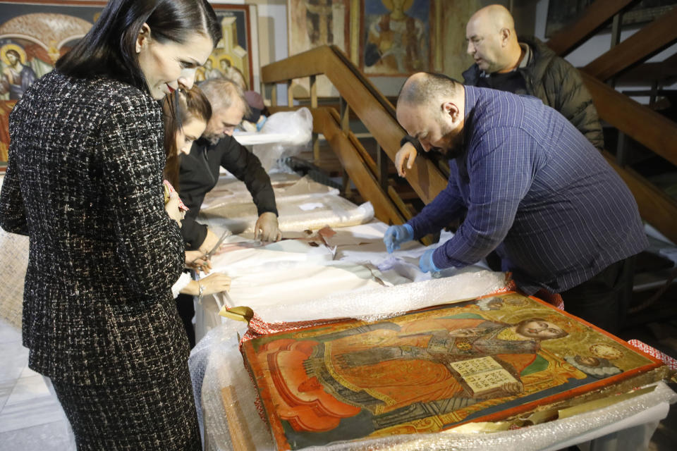 North Macedonia's Culture Minister Bisera Kostadinovska-Stojcevska, left, review icons returned from Albania, as presented upon the arrival at the National museum in Skopje, North Macedonia, late Friday, Dec. 15, 2023. Albania on Friday returned 20 icons to neighboring North Macedonia that were stolen a decade ago. (AP Photo/Boris Grdanoski)