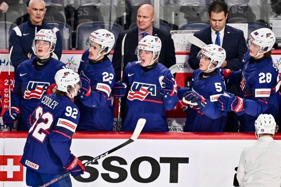 Peoria native Kevin Ricks (top left corner) looks on as Team USA celebrates a goal in the 2023 IIHF World Junior Championships in early January, 2023 in Canada. Ricks served as an athletic trainer for the USA Hockey bronze medal winners.