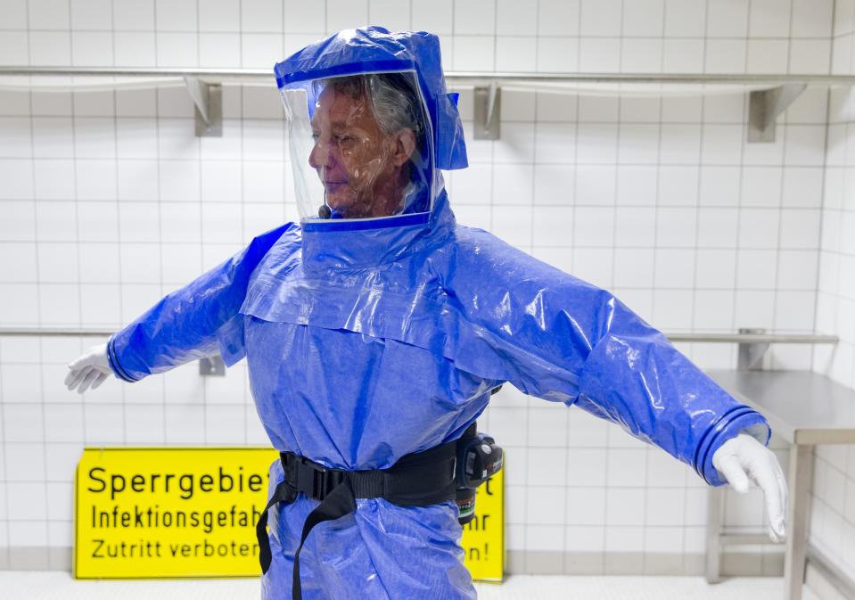 Ward physician Thomas Klotzkowski wears a protective suit at the quarantine station for patients with infectious diseases at the Charite hospital in Berlin August 11, 2014. The isolation ward at the Charite is one of several centres in Germany equipped to treat patients suffering from ebola and other highly infectious diseases, the clinic's doctor for tropical medicine Florian Steiner said. Ebola is one of the deadliest diseases known to humanity. It has no proven cure and there is no vaccine to prevent infection. The most effective treatment involves alleviating symptoms that include fever, vomiting and diarrhoea. The rigorous use of quarantine is needed to prevent its spread, as well as high standards of hygiene for anyone who might come into contact with the disease. The sign reads: "Do not Enter. Infectious Diseases. No Trespassing!" REUTERS/Thomas Peter (GERMANY - Tags: HEALTH)