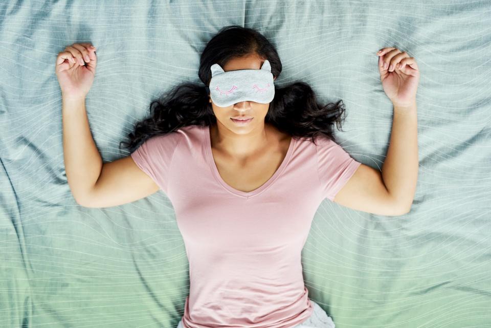 woman laying in bed with an eye mask on