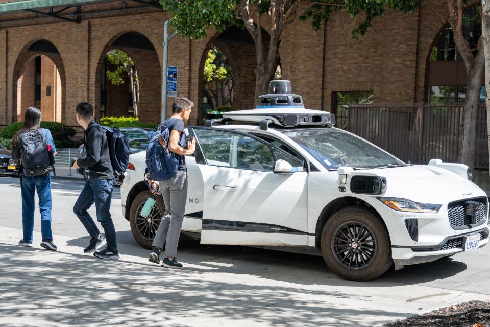 Pedestrians exit a Waymo self-driving car in front of Google's San Francisco headquarters, San Francisco, California, June 7, 2024. (Photo by Smith Collection/Gado/Getty Images)