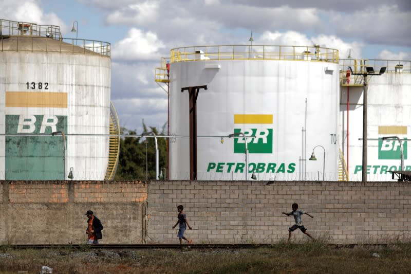 FOTO DE ARCHIVO. Personas caminan frente a los tanques de la empresa estatal de petróleo brasileña, Petrobras, en Brasilia.