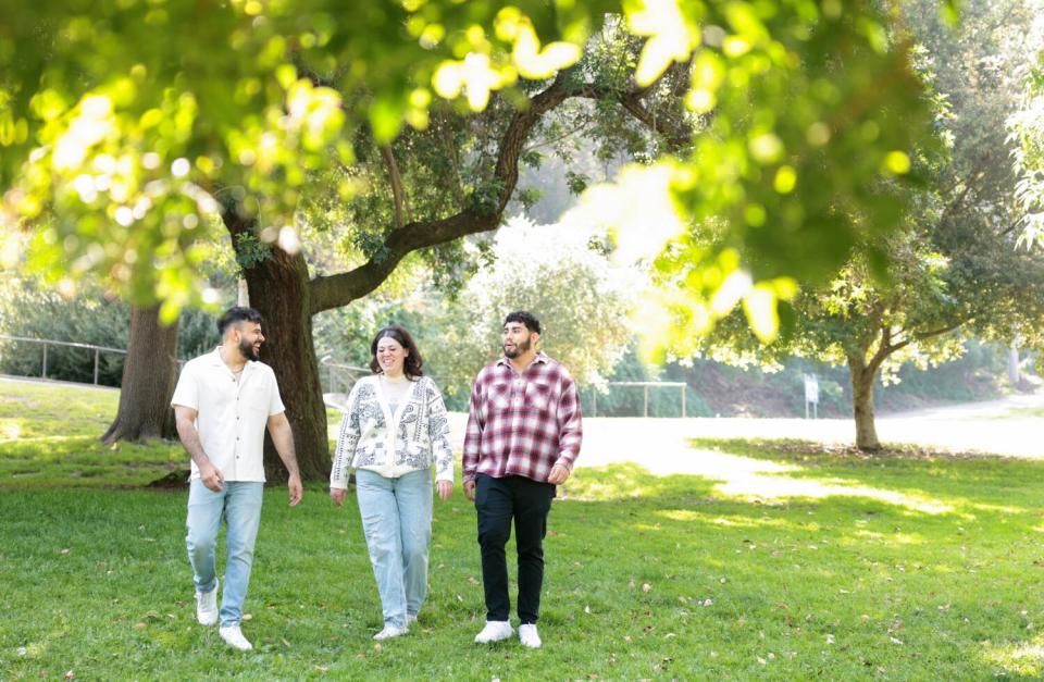 Three people walking in a park.