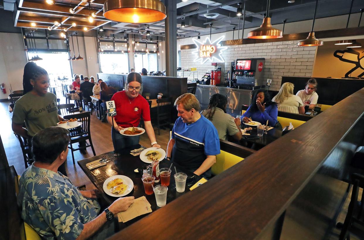 Grace Moses, a waitress at Vicious Biscuit, serves customers at the new restaurant in Copley June 14.