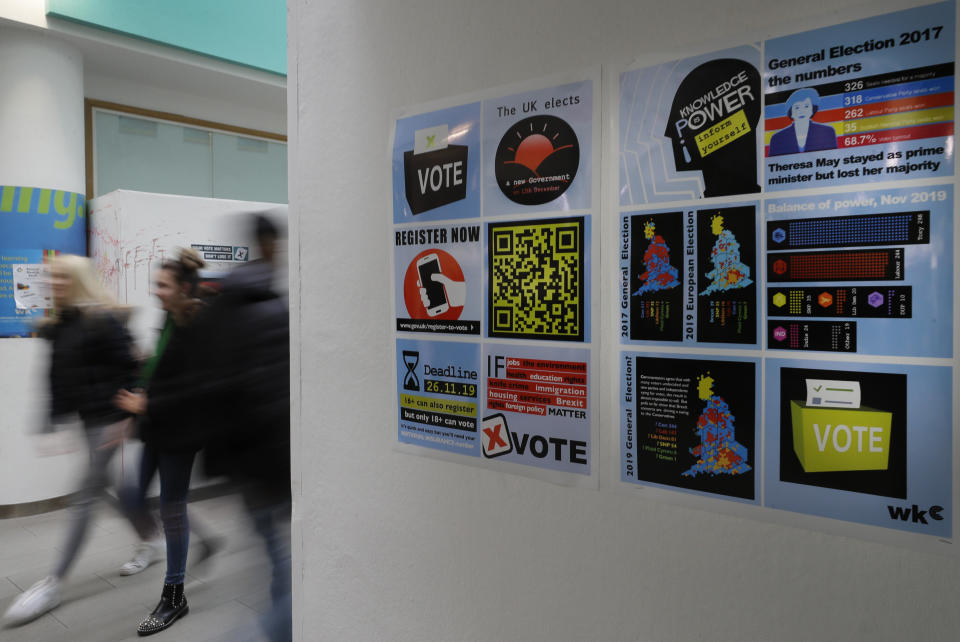 Posters on the wall encouraging students to register to vote, during a Vote For Your Future Hustings at Westminster Kingsway College in London, Tuesday, Nov. 19, 2019. There is a generation of young people who weren't old enough to vote in the Brexit referendum, but in a British election dominated by the Brexit issue those young voters could hold the key to victory for which-ever party can garner their vote. (AP Photo/Kirsty Wigglesworth)