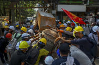 Anti-coup protesters build barricades to block police in Yangon, Myanmar, Thursday, March 4, 2021. Demonstrators in Myanmar protesting last month's military coup returned to the streets Thursday, undaunted by the killing of at least 38 people the previous day by security forces. (AP Photo)