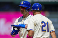 Seattle Mariners designated hitter Mitch Garver, left, reacts after hitting an RBI single against the Oakland Athletics to score Dylan Moore as first base coach Kristopher Negrón (21) looks on during the first inning of a baseball game Sunday, May 12, 2024, in Seattle. (AP Photo/Lindsey Wasson)