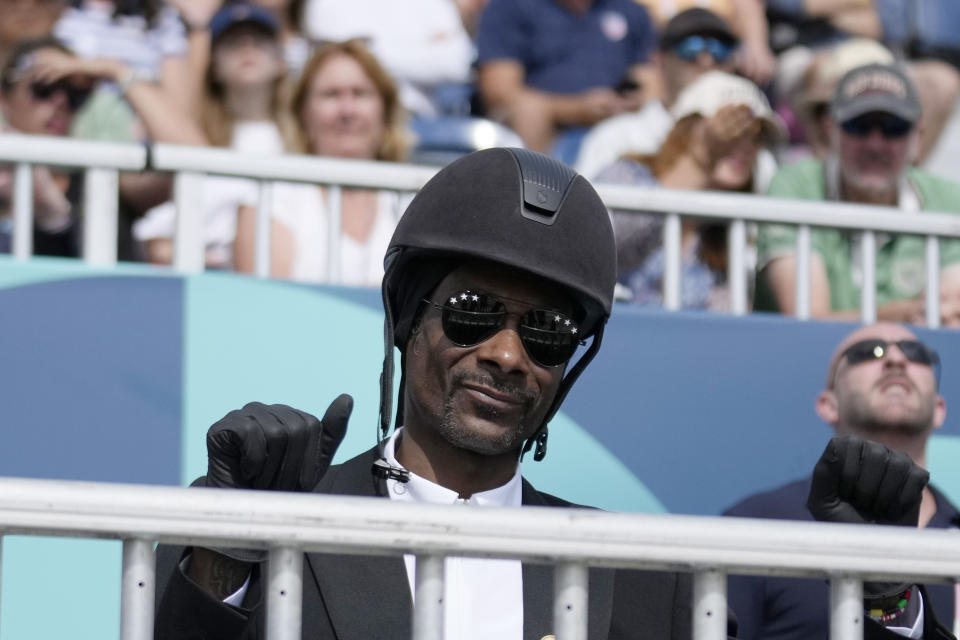 Snoop Dogg levanta el pulgar mientras observa la final del Gran Premio por equipos de doma en los Juegos Olímpicos de Verano de 2024, el sábado 3 de agosto de 2024, en Versalles, Francia. (Foto AP/Mosa'ab Elshamy)